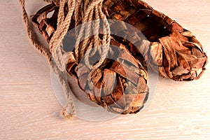 Birchen woven bast shoes hang on a log wall