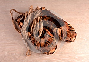 Birchen woven bast shoes hang on a log wall