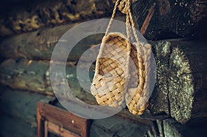 Birchen woven bast shoes hang on a log wall