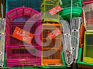 Bird cages with sold out signs in closeup, Pet trade in Asia, Animal business background