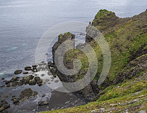 Bird cliff rocks in atlantic ocean with lava rock formation sea and blue sky backgound, summer in nature reserve in Hornstrandir