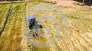 Bird eye of Hay rake tractor turning the hay