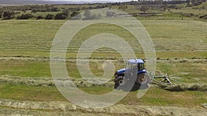 Bird eye of hay rake tractor turning the hay