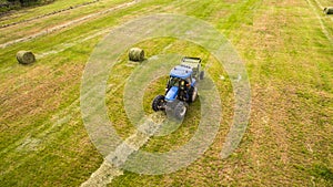Bird eye of Man at work on the tractor with hay baler