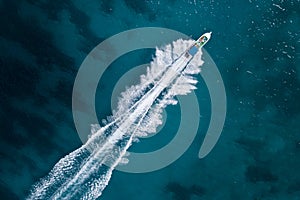 Bird eye view of motor boat with wake at sea