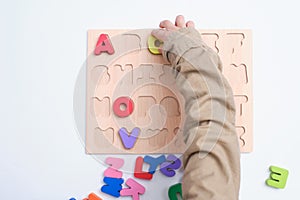 Bird eye view of preschooler, kindergarten boy playing with alphabet blocks, Children learning English with wooden educational abc