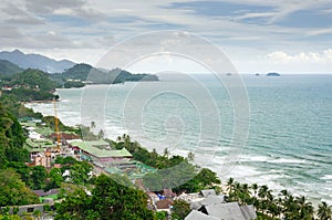 Bird eye view of sea coastline with white sand beach, coconut palm trees, hotels, resorts and tropical sea on Koh Chang island