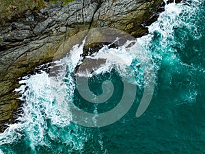 Bird eye view seashore with big wave crashing on rock cliff. Beautiful waves sea surface in sunny day summer background, Amazing