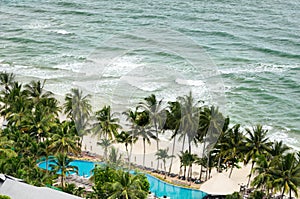 Bird eye view of white sand beach, coconut palm trees, hotels, resorts and tropical sea surf on Koh Chang island in Thailand