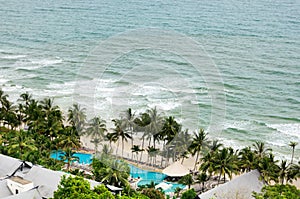 Bird eye view of white sand beach, coconut palm trees, hotels, resorts and tropical sea surf on Koh Chang island in Thailand