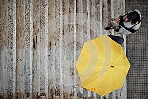 Bird-eye view of a young couple in love which is ascending the stairs in the city during a rainy day. Walk, rain, city,