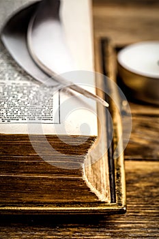 Bird feather on old Bible