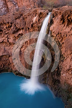 A bird`s eye view of the 200ft Mooney Falls surges in to a beautiful deep blue pool beneath, located on the Havasupai Indian Reser