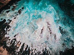 Bird`s eye view of the broken beach in Nusa Penida, Indonesia. Waves and foam, abstract background, drone photography