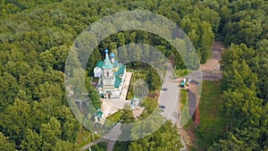 Bird's-eye view. Clip. A beautiful green forest with a monastery in the middle . There are also some roads and some