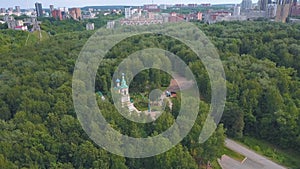 Bird's-eye view. Clip. A beautiful green forest with a monastery in the middle . There are also some roads and some