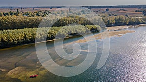 Bird`s eye view of couple travelling by kayak in the river with visible bottom and estuary