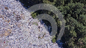 Bird`s eye view of ecological disaster, garbage dump on the border with forest