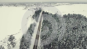 Bird's eye view of a small country road in winter, snow all around.