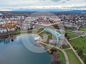 Bird's eye view of a small lake in the town und a beautiful cloudy sky