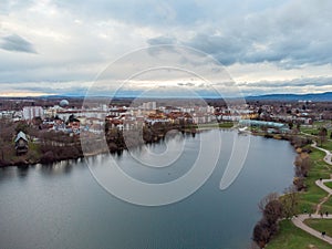 Bird's eye view of a small lake in the town under a beautiful cloudy sky