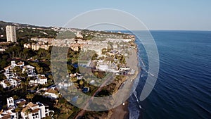 Bird's-eye view of an urban landscape meeting the azure sea, under the warm glow of sunset. Costa Del Sol, Marbella