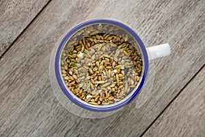 Bird seed in an enamel cup photo