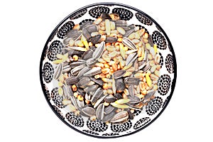 Bird seeds. Close-up of a decorative bowl with black sunflower seeds and other seed and nuts for feeding wild birds. Animal