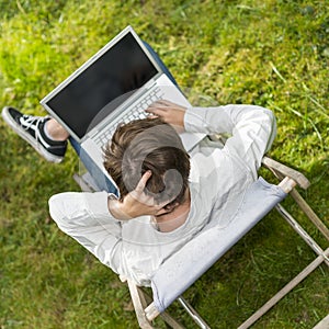 Bird view on young man with his laptop computer outdoors