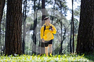 Bird watcher is looking through binoculars while exploring in the pine forest for surveying and discovering the rare biological