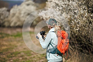 Bird watching. Woman ornithologist with binoculars observes birds arriving in spring