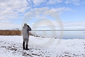 Birder by a coast in winter season photo