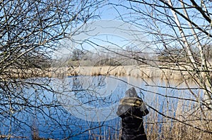 Birder by a pond in spring season photo