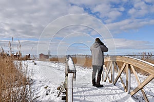 Birder on a wooden footbridge photo