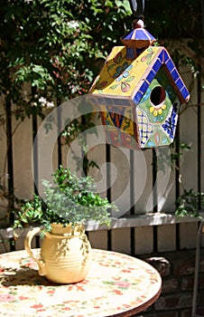Birdhouse and plant in pitcher photo