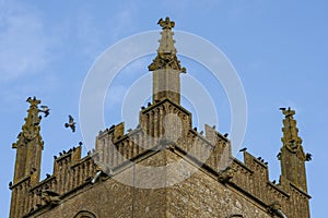 Birds arrive at evening time to roost on tower of Saint Edwards medieval church in Stow on Wold photo