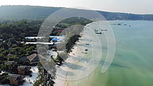 Birds eye drone aerial view of single pier in crystal clear blue sea on secluded beach on Cambodian island Koh Rong on