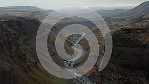 Birds eye stunning and surreal landscape of Haifoss valley in Iceland with river Fossa flowing on riverbed. Aerial view