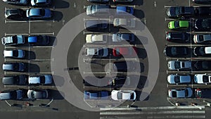 Birds eye view cars moving at parking. Drone filming congested parking lot