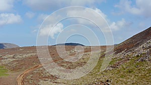 Birds eye view of man doing motocross on desert greenland in Iceland. Aerial drone view of rider driving motorcycle