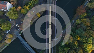 Birds eye view of S Bahn train crossing river on multitrack bridge. Autumn city at golden hour. Berlin, Germany