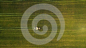 Birds-eye view of a tractor working in a green field