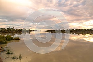 Birdsville lagoon at sunset with clouds reflected in the water photo