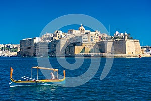 Birgu, Malta, 22 May 2022 : Traditional boat in front of the Castle of Birgu, one of the Three Cities of Malta