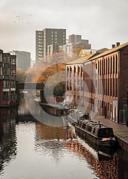 Birmingham gas basin narrowboat with moored canal boats and cityscape modern skyline behind