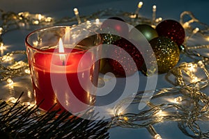 Birning red christmas candle with decorations at night, christmas eve mistery concept