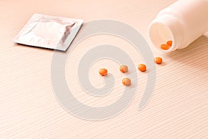 Birth control pills and condom on light background. The concept