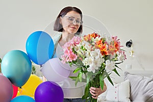 Birthday, 45 years old, happy female with bouquet of flowers and balloons