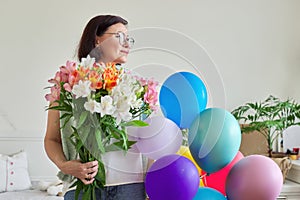Birthday, 45 years old, happy female with bouquet of flowers and balloons