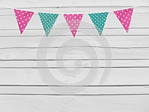 Birthday or baby shower mockup scene. String of pink and mint dotted fabric flags. Party decoration. Old white wooden